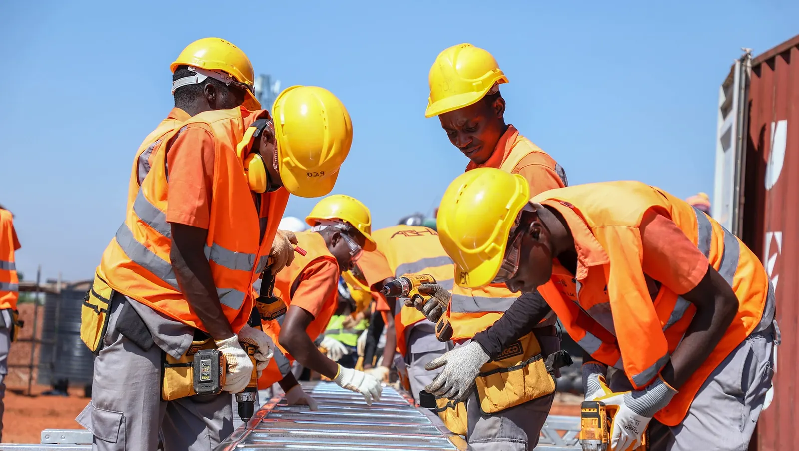 Equipe de obra com EPI trabalhando em canteiro