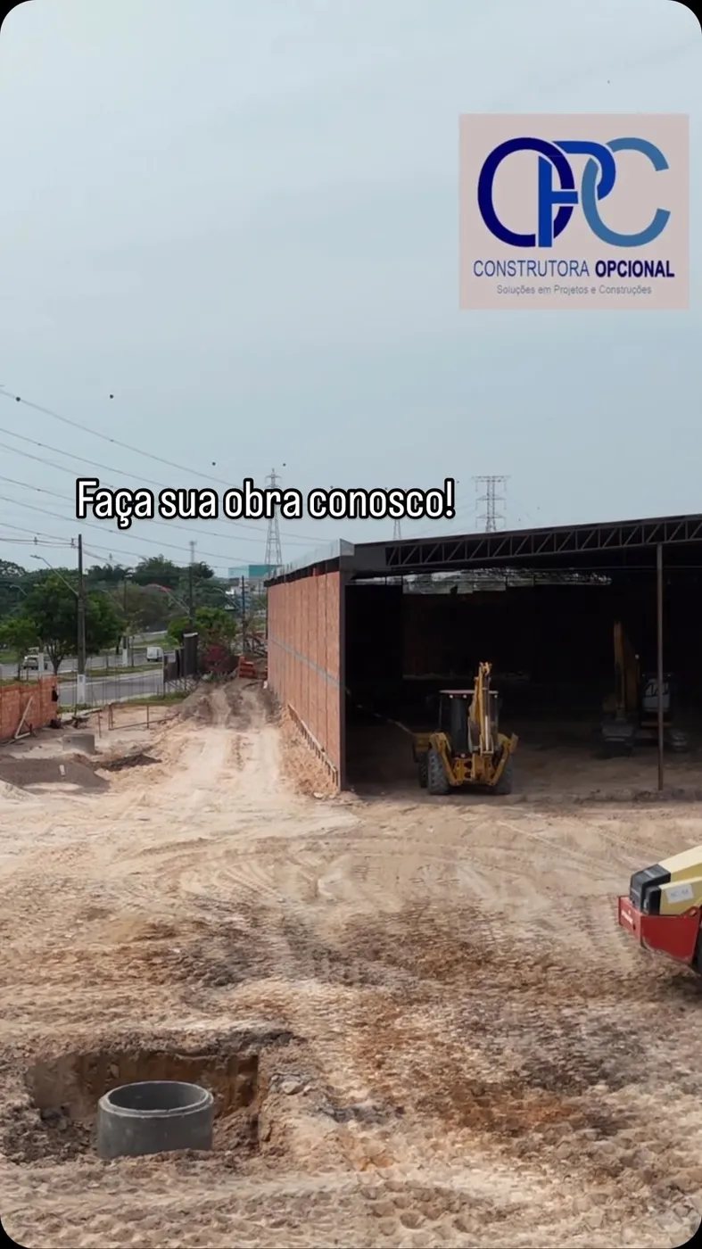 Galpão comercial em construção com retroescavadeira