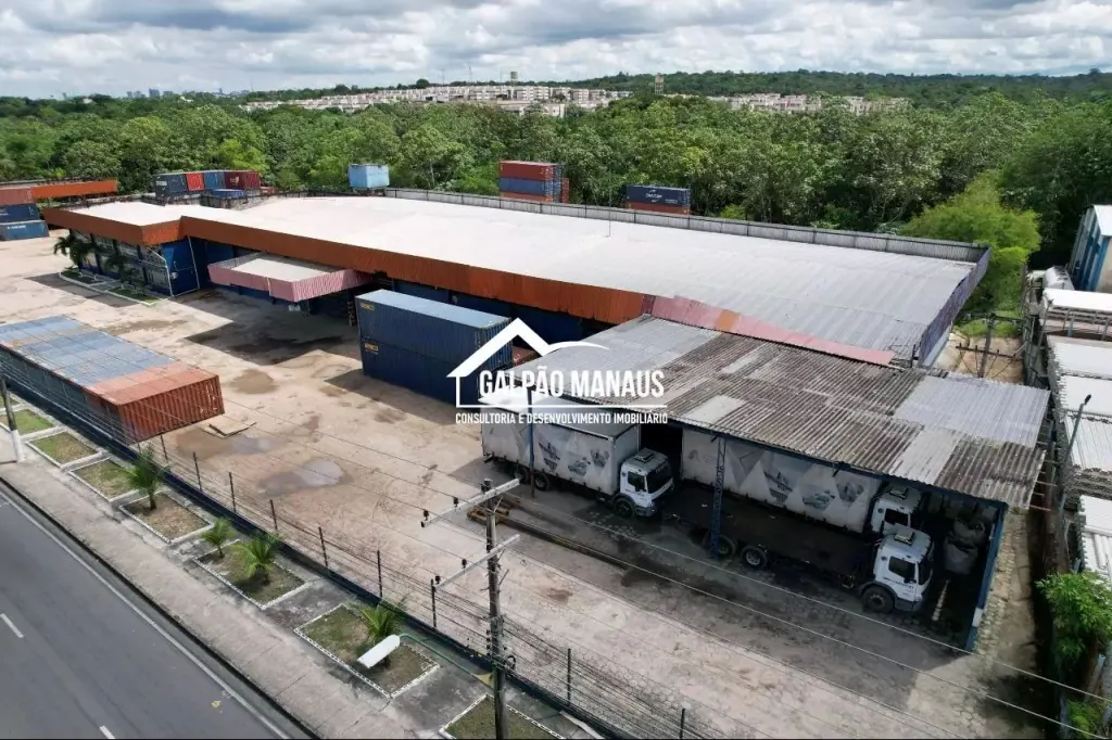 Vista aérea de galpão logístico com pátio de docas cobertas e caminhões estacionados