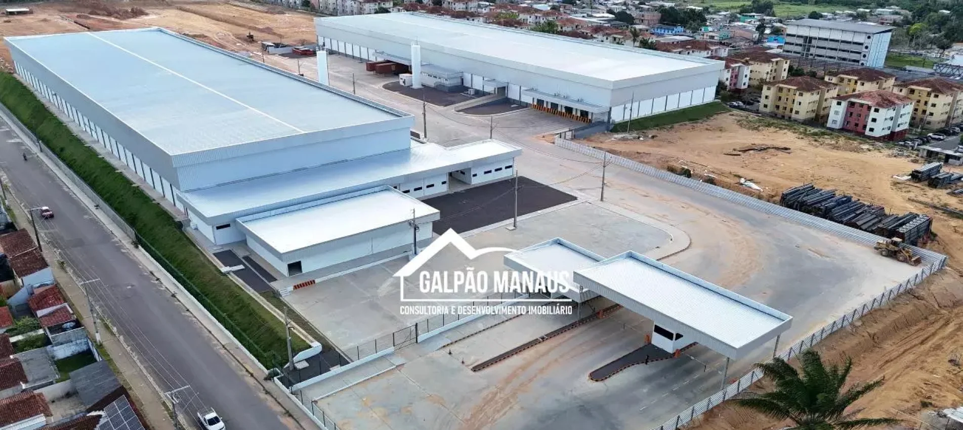 Vista aérea de um complexo de galpões logísticos com telhado metálico, pátio de manobra, guarita e vias de acesso, no Distrito Industrial de Manaus
