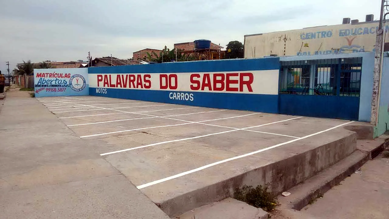 Fachada do Centro Educacional Palavras do Saber, com o muro azul e o estacionamento próprio