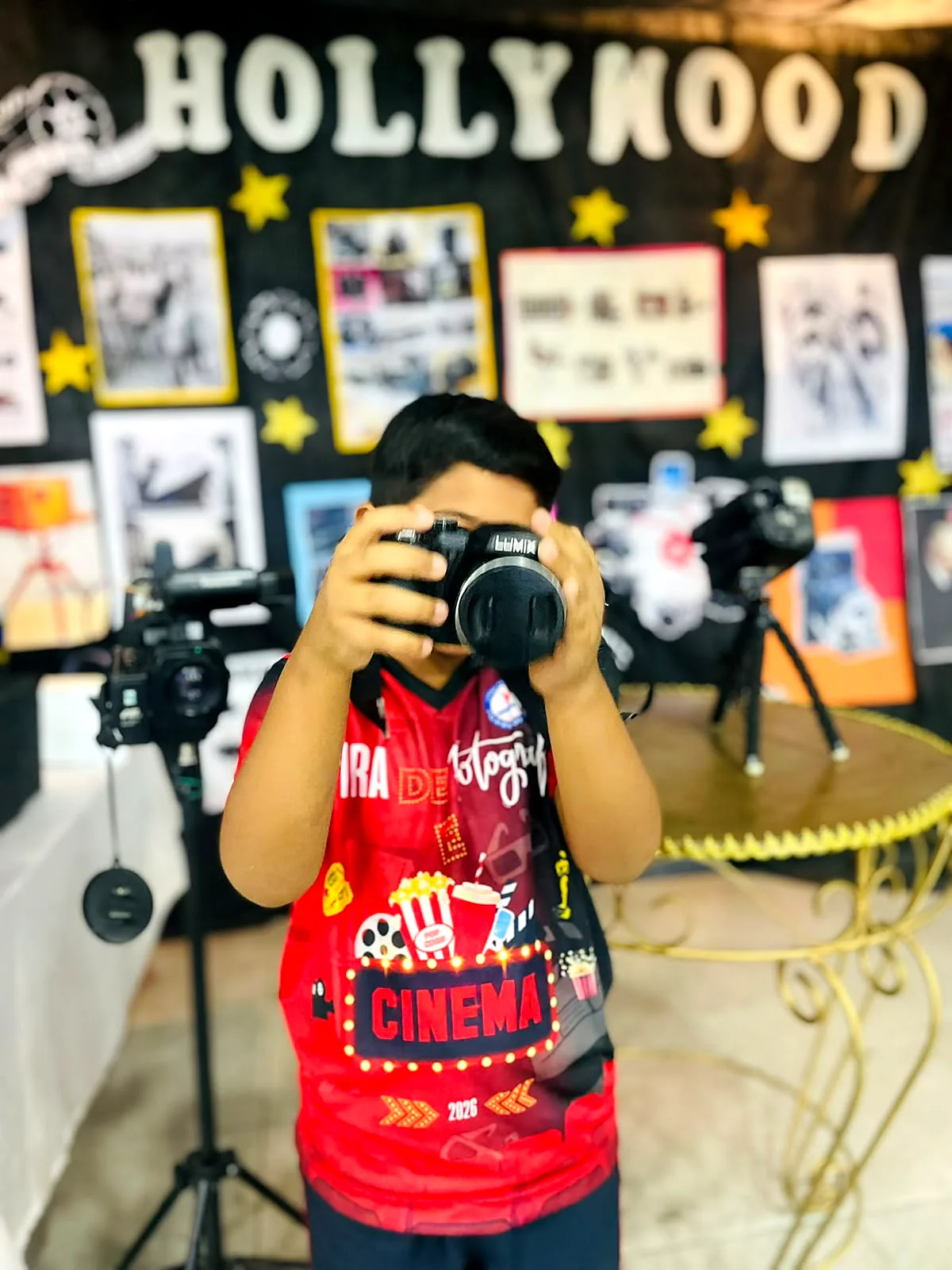 Aluno fotografando na feira de cinema da escola