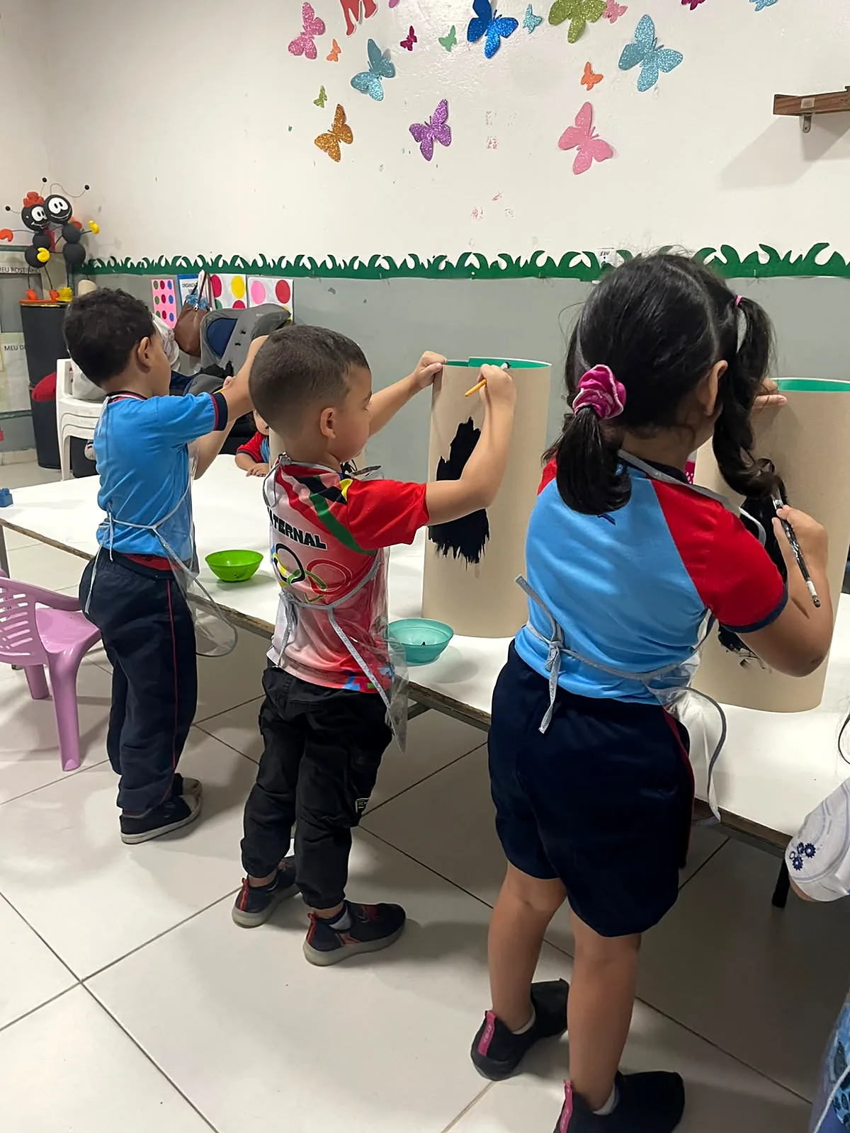 Crianças da Educação Infantil pintando em atividade de artes